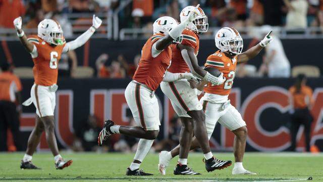 Miami Hurricanes linebacker Chase Smith (41) celebrates with teammates after intercepting the ball in the second half of the NCAA football game against the South Florida Bulls at Hard Rock Stadium in Miami Gardens, Florida, on Saturday, September 13, 2025.