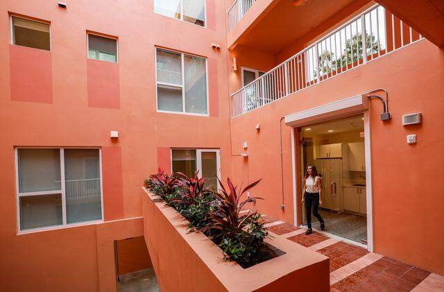 Laura Weinstein-Berman, owner and developer of Project Peach, walks inside the innovative but compact new building in Overtown that combines design flair with three affordable apartments, offices, a retail space on a small substandard lot. It's an intense peach/salmon color that recalls a popular peach soda once produced in overtown by a black-owned company. The building, which recently opened, also includes community space where the developer is planning an exhibit of Overtown photos in Miami, Florida, on Tuesday, March 3, 2026. Project Peach building is located at 123 NW 14th Street, in the Overtown area of Miami.