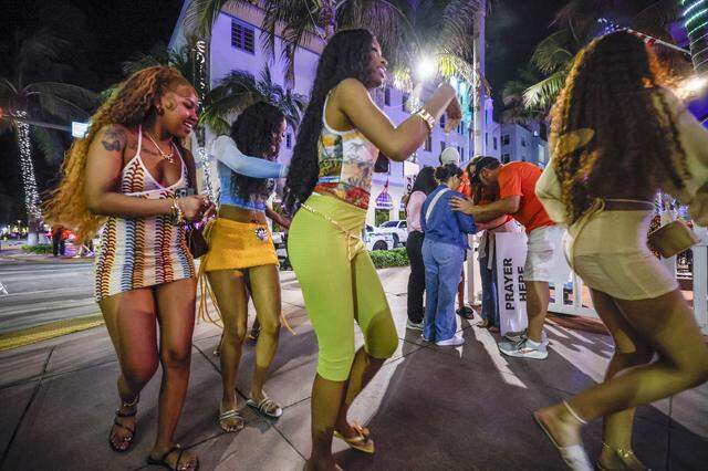 Women walk along Ocean Drive as a group prays with the God Squad, an interfaith prayer team of volunteers for the Miami Beach Police Department who serve as goodwill ambassadors during spring break in the South Beach neighborhood of Miami Beach Florida on Friday, March 20, 2026.