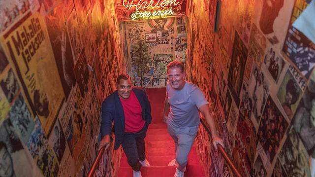 Co-owners Michael Simkins (left) and Derek Fleming, posed on the stairs leading up to the the pool hall at the Red Rooster restaurant located in the heart of Miami's historic Overtown neighborhood, on Friday, March 13, 2026.