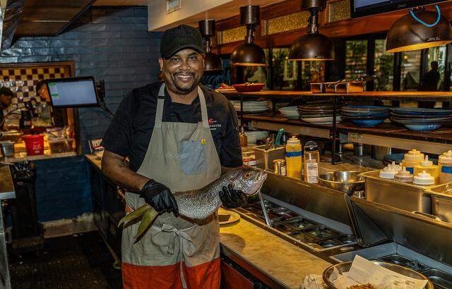 Charles Page Jr. Executive Chef gets ready to prepare a whole Snapper fish in the kitchen   at the Red Rooster restaurant located in the heart of Miami's Overtown neighborhood, on Friday, March 13, 2026.