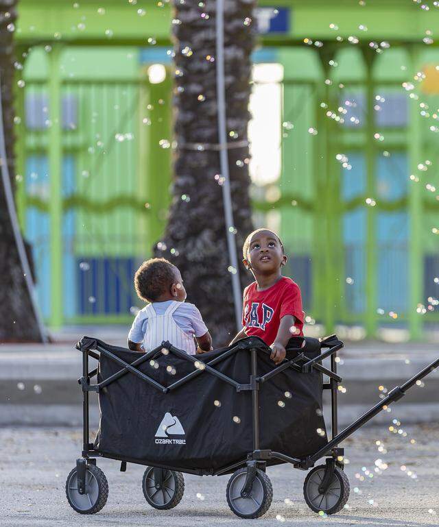 Jamal Mair, 2, right, and his brother, Jay Mair, 10-months-old, react as bubbles float overhead during the opening day of the 74th annual Miami-Dade County Youth Fair on Thursday, March 12, 2026, in Miami, Fla.