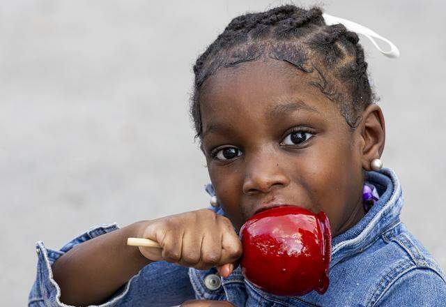 Bailey Williams, 4, bites into a candy apple during the opening day of the 74th annual Miami-Dade County Youth Fair on Thursday, March 12, 2026, in Miami, Fla.