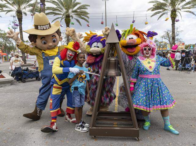 Landon Rogers, 13, surrounded by mascots, rings a bell to celebrate the start of the 74th annual Miami-Dade County Youth Fair on Thursday, March 12, 2026, in Miami, Fla.
