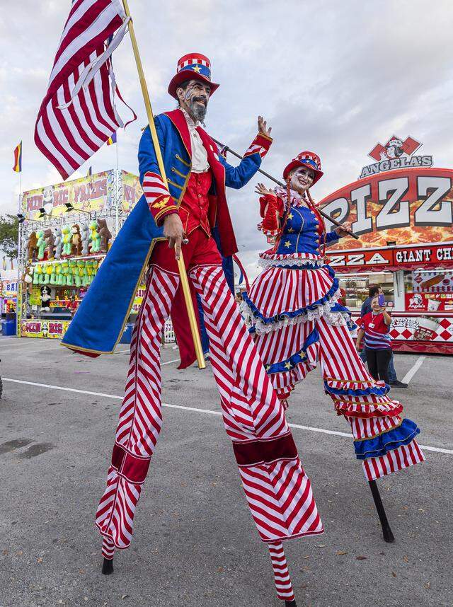 Star Child and Rich Dalton, members of the Stilt Circus, greet guests as they march in a parade during the opening day of the 74th annual Miami-Dade County Youth Fair on Thursday, March 12, 2026, in Miami, Fla.