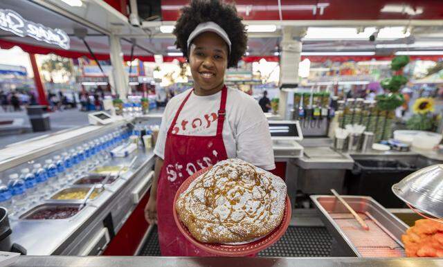 An elephant ear with caramel and powdered sugar is prepared for guests attending the opening day of the 74th annual Miami-Dade County Youth Fair on Thursday, March 12, 2026, in Miami, Fla.