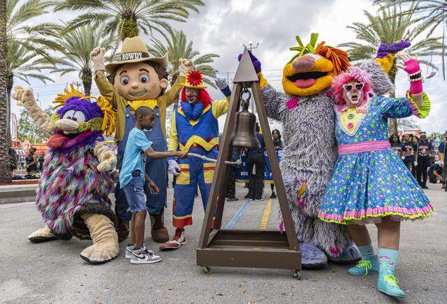 Landon Rogers, 13, surrounded by mascots, rings a bell to celebrate the start of the 74th annual Miami-Dade County Youth Fair on Thursday, March 12, 2026, in Miami, Fla.