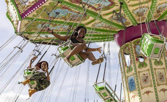 Abigail Sculley, center, and Rakale McCormick react as they ride a swing attraction during the opening day of the 74th annual Miami-Dade County Youth Fair on Thursday, March 12, 2026, in Miami, Fla.