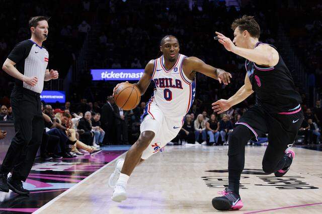 Philadelphia 76ers guard Tyrese Maxey (0) drives around Miami Heat guard Pelle Larsson (9) during the second half of a game on Monday, March 30, 2026, at the Kaseya Center in downtown Miami, Fla. 