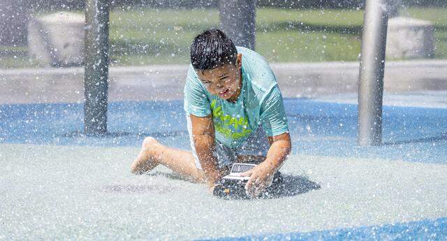 Mateo Tuesta, 7, plays with a toy at the splash pad in South Pointe Park as hot weather moves through the area on Friday, Aug. 15, 2025, in Miami Beach, Fla. Forecasters have issued heat advisories throughout the summer in South Florida, with temperatures at times feeling as hot as 109 degrees.
