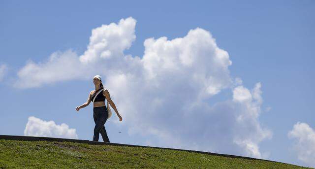 A woman walks through South Pointe Park as hot weather moved through the area on Aug. 15, 2025, in Miami Beach, Fla. Forecasters issued heat advisories throughout the summer in South Florida. Spring break week March 9-15, 2026, won’t be as hot. But it’ll feel a toasty season in the mid-80s.