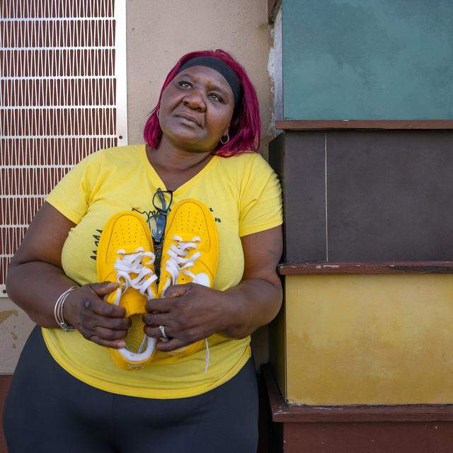 Lasonja Mills, mother of 16-year-old Brandon Mills who was killed in a mass shooting in 2009, hugs the shoes that her son was killed in. She returned in August 2024 to where his body was found near Northwest 15th Avenue in Liberty City. ‘His father used to call him yellow,’ said Mills.