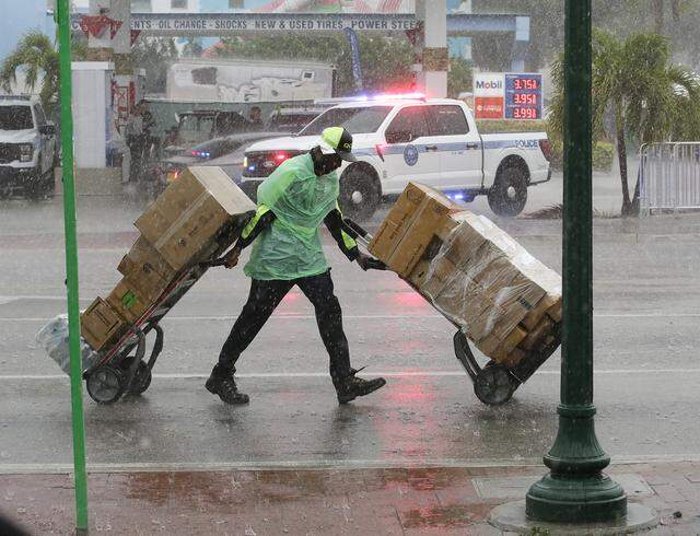 The endless rain makes the vendor's work difficult during Calle Ocho festival on Sunday, March 15, 2026 in Little Havana. Andrew Uloza / for Miami Herald