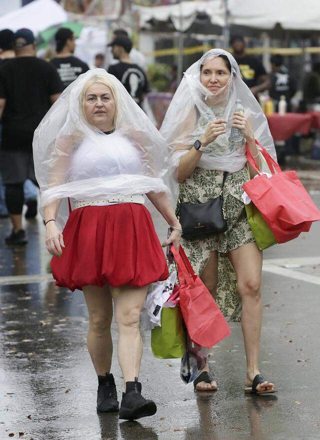 Anything helps to protect against endless rain during Calle Ocho festival on Sunday, March 15, 2026 in Little Havana. Andrew Uloza / for Miami Herald