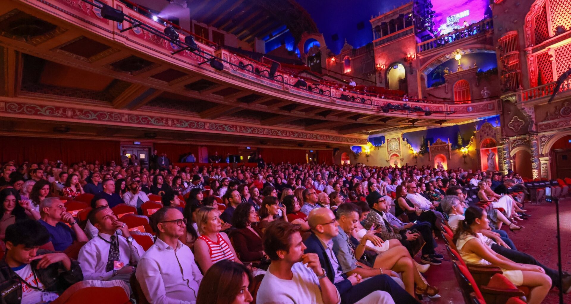 photo of a packed theater bathed in purple lighting during the Miami Film Festival