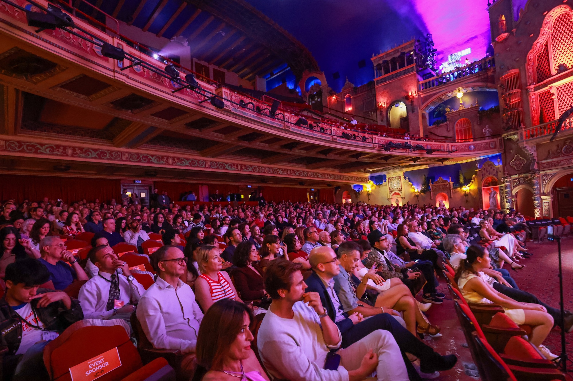photo of a packed theater bathed in purple lighting during the Miami Film Festival