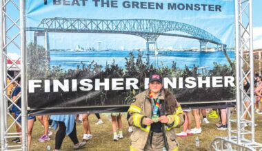 Christina Munro, a member of the Lake City Fire Department, holds her medal after finishing the Gate River Run in Jacksonville last week. Munro did the 15K run in her firefighting gear. (COURTESY)
