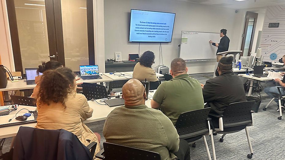 Students sit in classroom learning about IT. (Spectrum News)