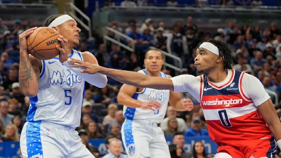 Orlando Magic forward Paolo Banchero (5) grabs a rebound in front of Washington Wizards guard Bilal Coulibaly (0) during the first half of an NBA basketball game, Thursday, March 12, 2026, in Orlando, Fla. (AP Photo/John Raoux)
