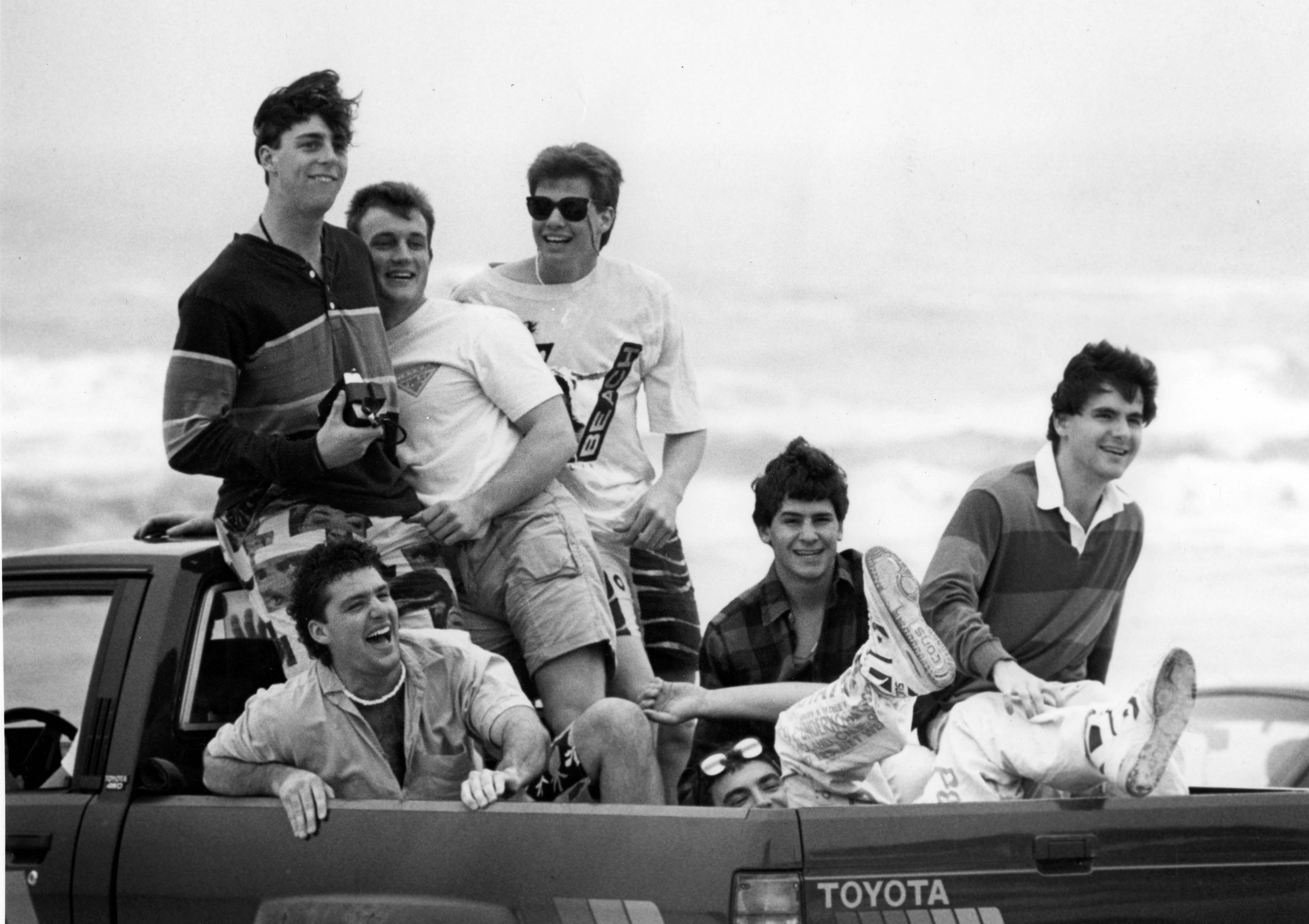 A pickup truck full of college students enjoy themselves driving...