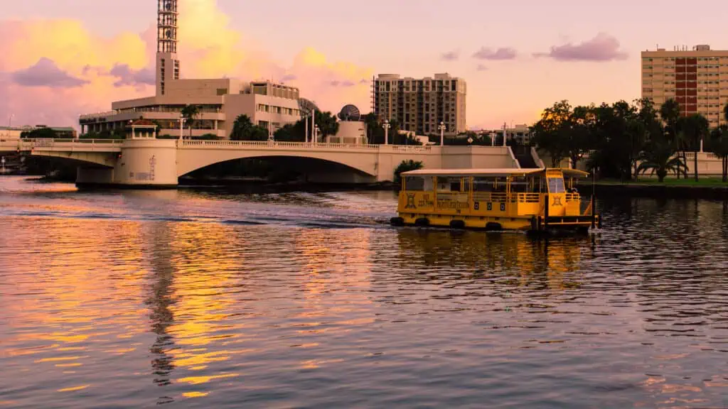 a yellow water taxi rides during sunset
