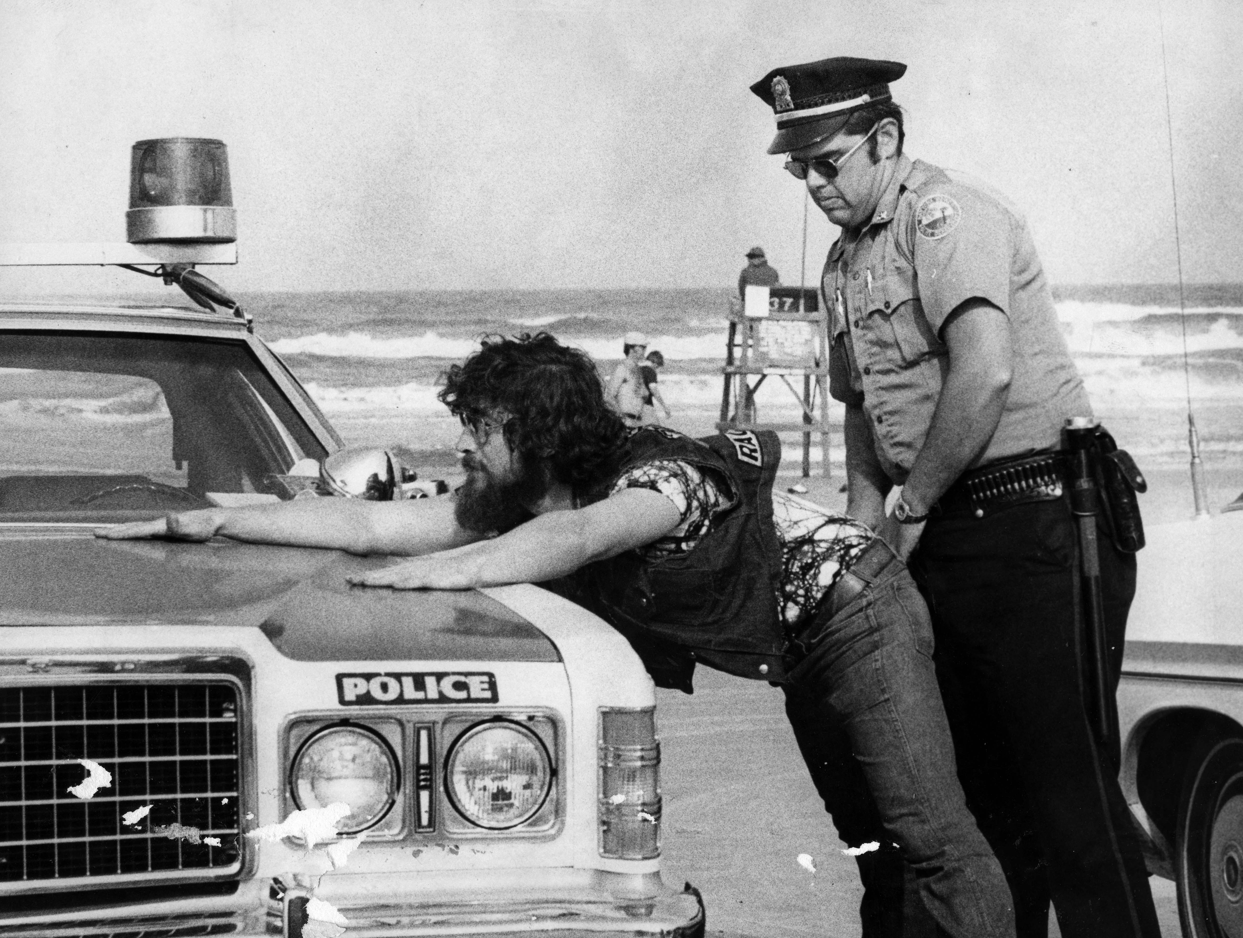 A Daytona Beach police officer makes a routine search of...