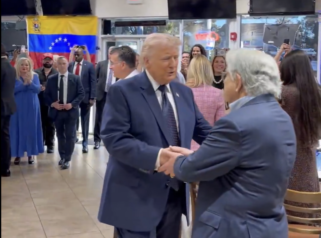 President Donald Trump shaking hands at a restaurant in Doral