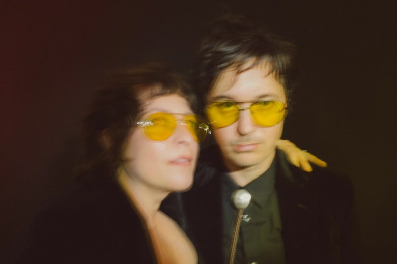 Shovels & Rope band members wearing yellow-tinted aviator sunglasses and black western-inspired attire, including a bolo tie, posing for a cinematic horizontal press photo against a dark background.