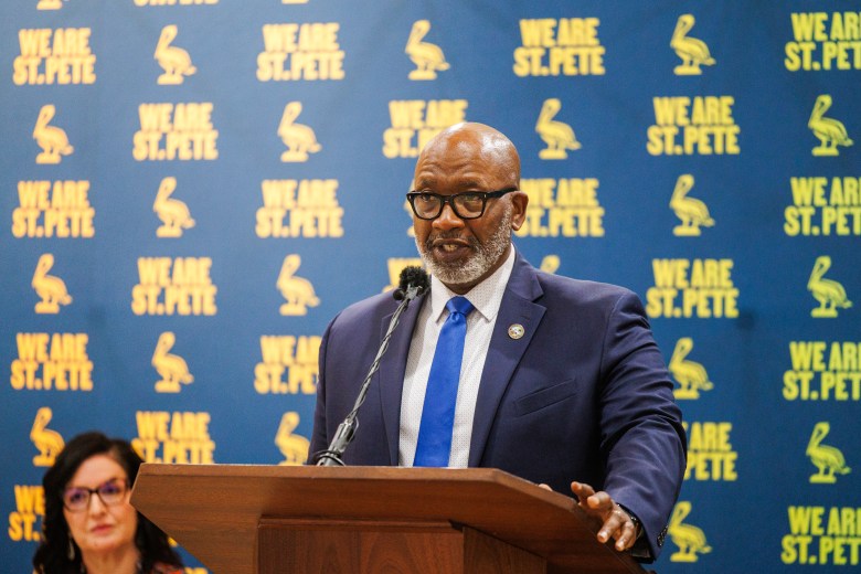St. Petersburg Mayor Ken Welch speaking at a podium during the Renter Utility Relief Program press conference in March 2024. The background features a "We Are St. Pete" branded backdrop.