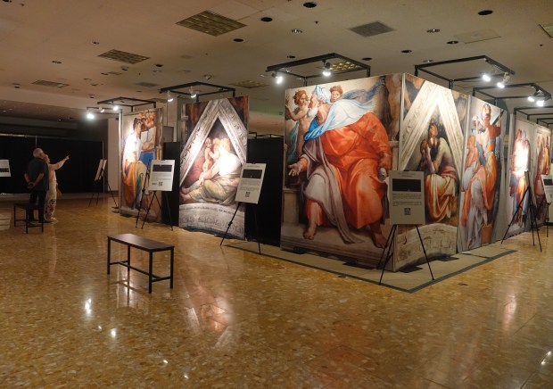 Visitors view large-scale panels at Michelangelo's Sistine Chapel: The Exhibition, hosted at the Galleria Mall in Fort Lauderdale, Fla., on Wednesday, March 11, 2026. The traveling exhibit uses high-definition photography to bring the Vatican's ceiling frescoes to eye level. (Joe Cavaretta/South Florida Sun Sentinel)