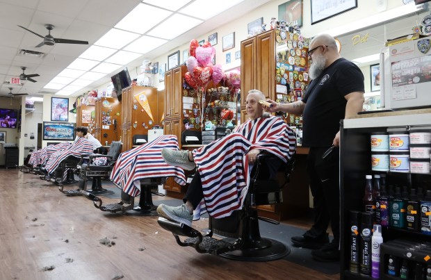 Del Brito, owner of Del's Barber Shop in the Indian Trace Center, cuts the hair of customer Joe Ankus on Feb. 16, 2026, in Sunrise. Brito is in favor of a proposed hotel behind the plaza. "The developer came and met with us and said the plaza would remain the same but that the entry signage and roads would be fixed up," Brito said. (Joe Cavaretta/South Florida Sun Sentinel)