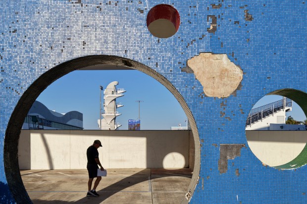 A man walks past the International Swimming Hall of Fame and Fort Lauderdale Aquatic Center on March 14, 2025. (Amy Beth Bennett/South Florida Sun Sentinel)