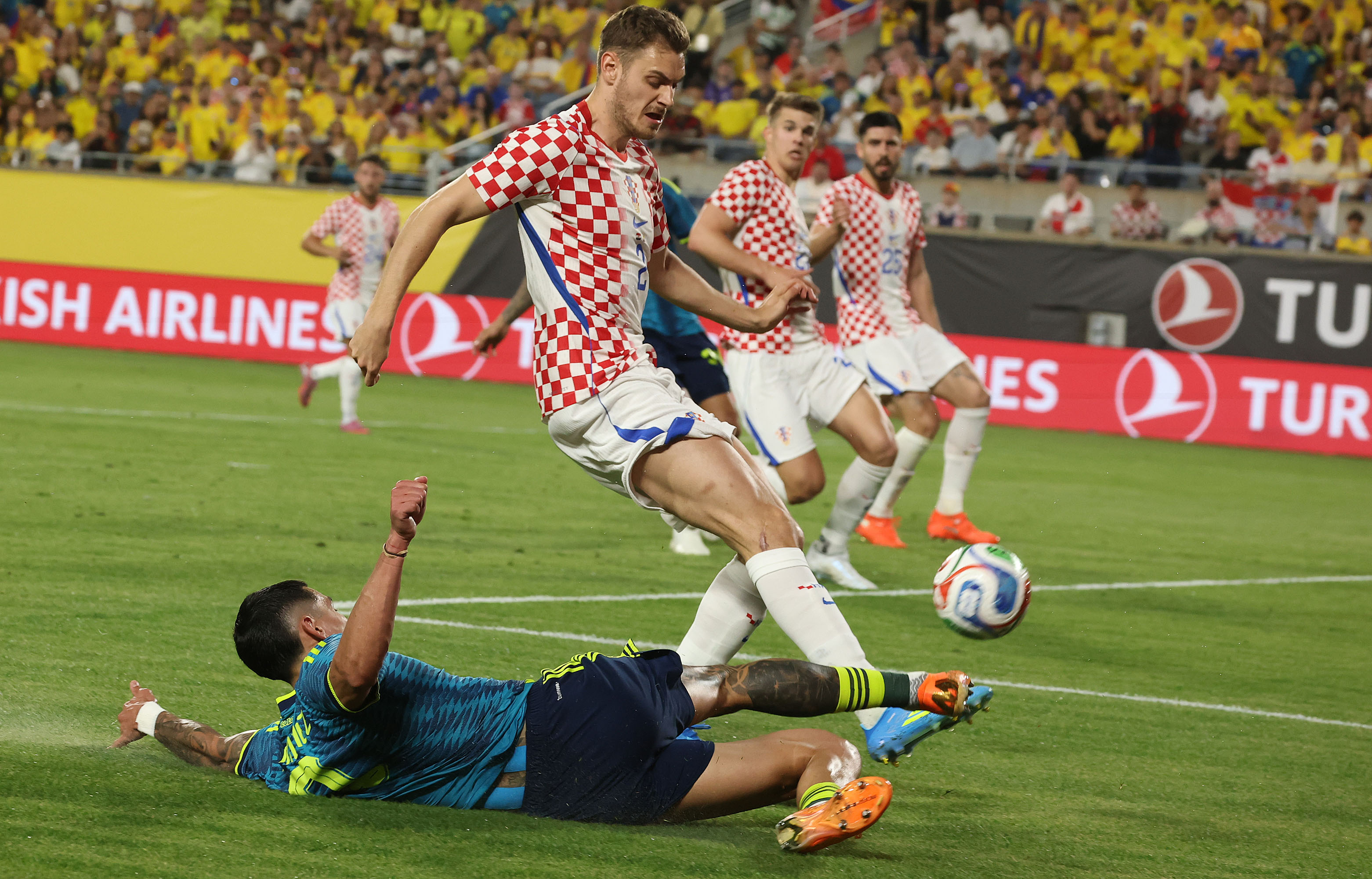 Colombia player D. Munoz (bottom) slides under Croatia player Josip...