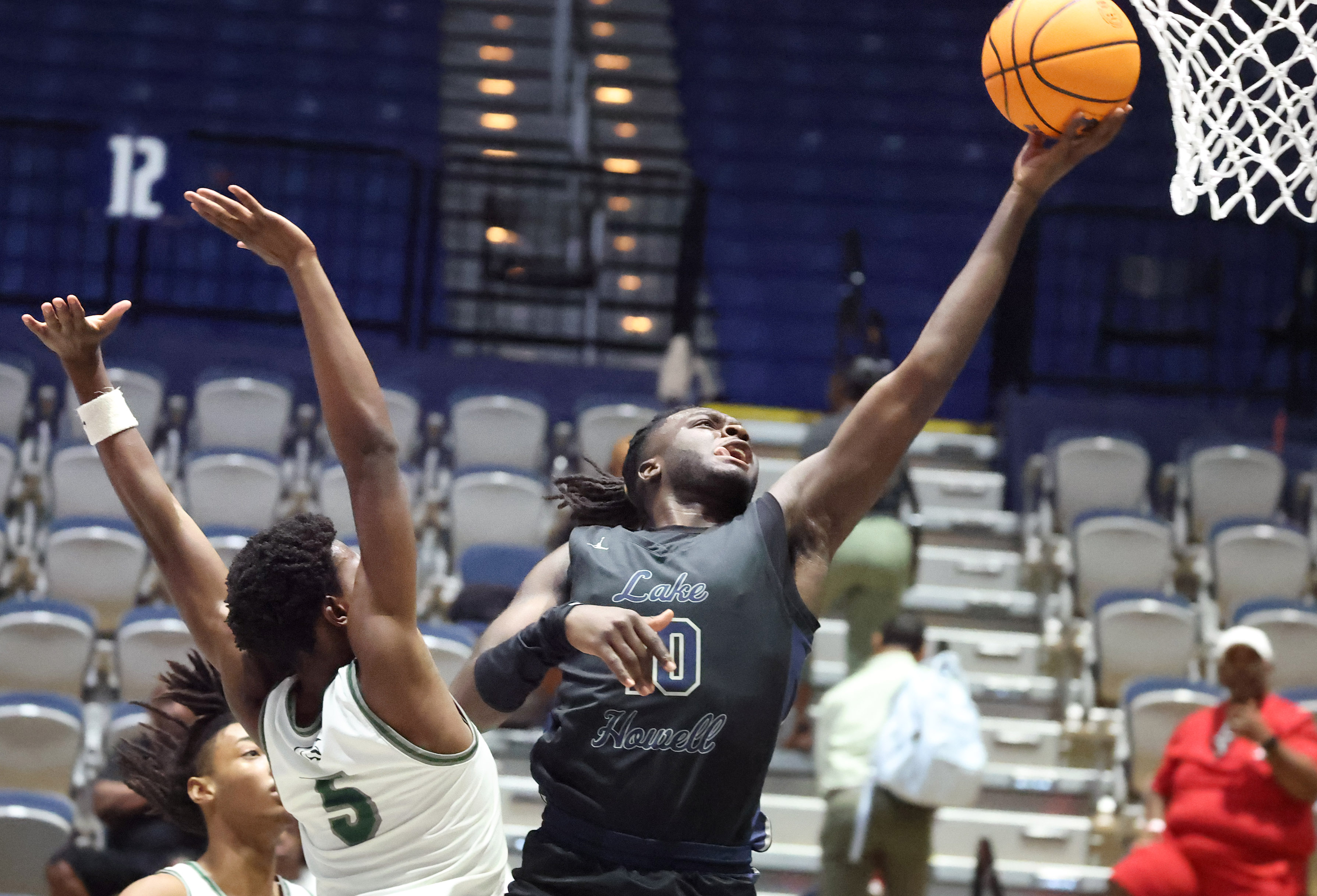 Lake Howell player Isaac Buckley (10) scores over Evans player...