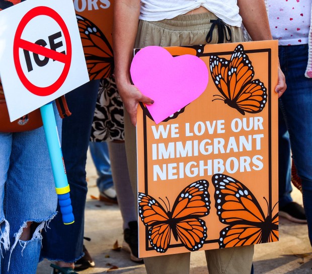 Protesters hold signs outside the Orange County Administration building in downtown Orlando, Tuesday, March 10, 2026. The county commission was scheduled to vote Tuesday on a resolution opposing plans to convert an Orange County warehouse into an Immigration and Customs Enforcement detention facility. (Joe Burbank/Orlando Sentinel)
