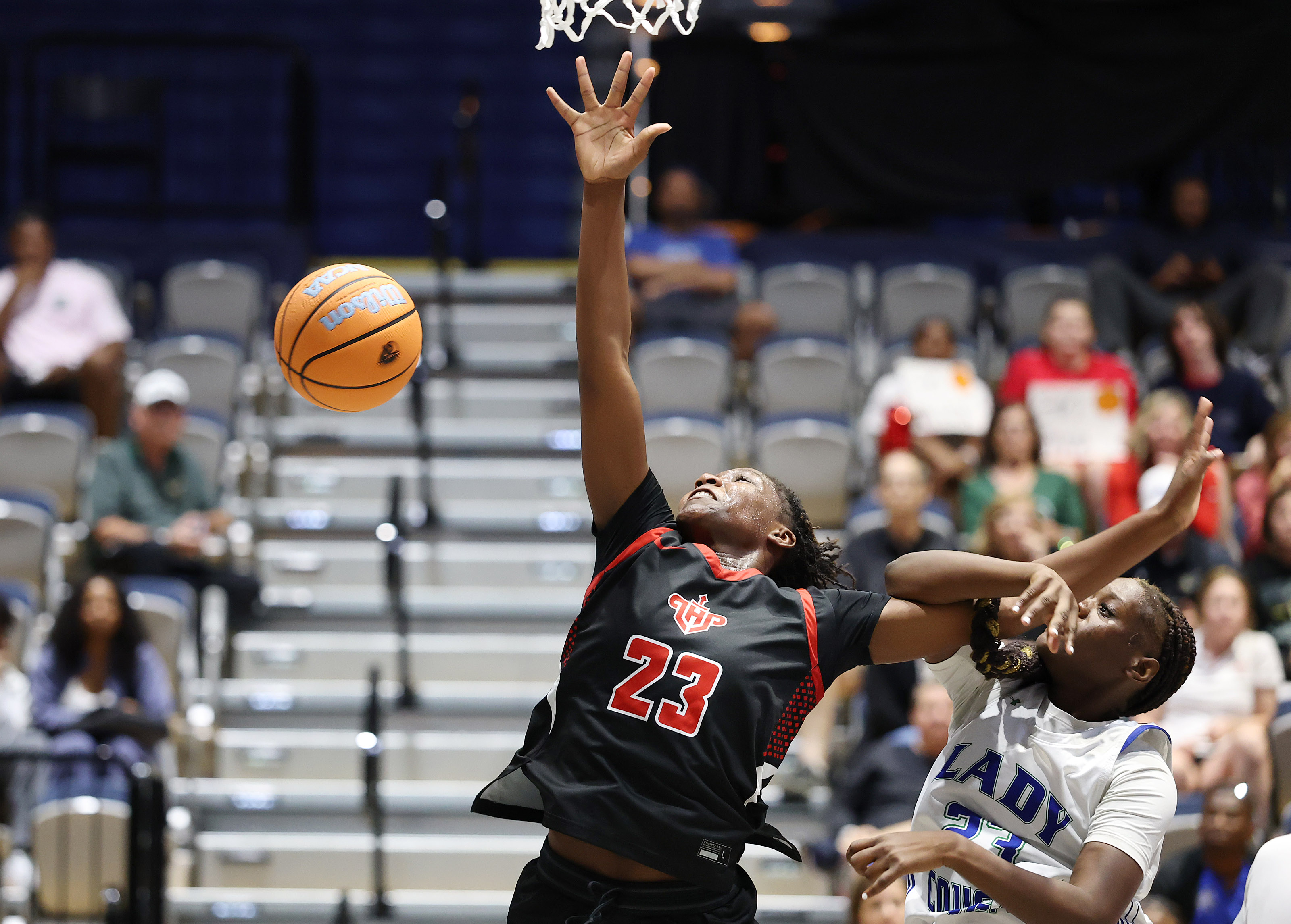 Lake Highland player Saleigh Simpson (23 left) is fouled by...
