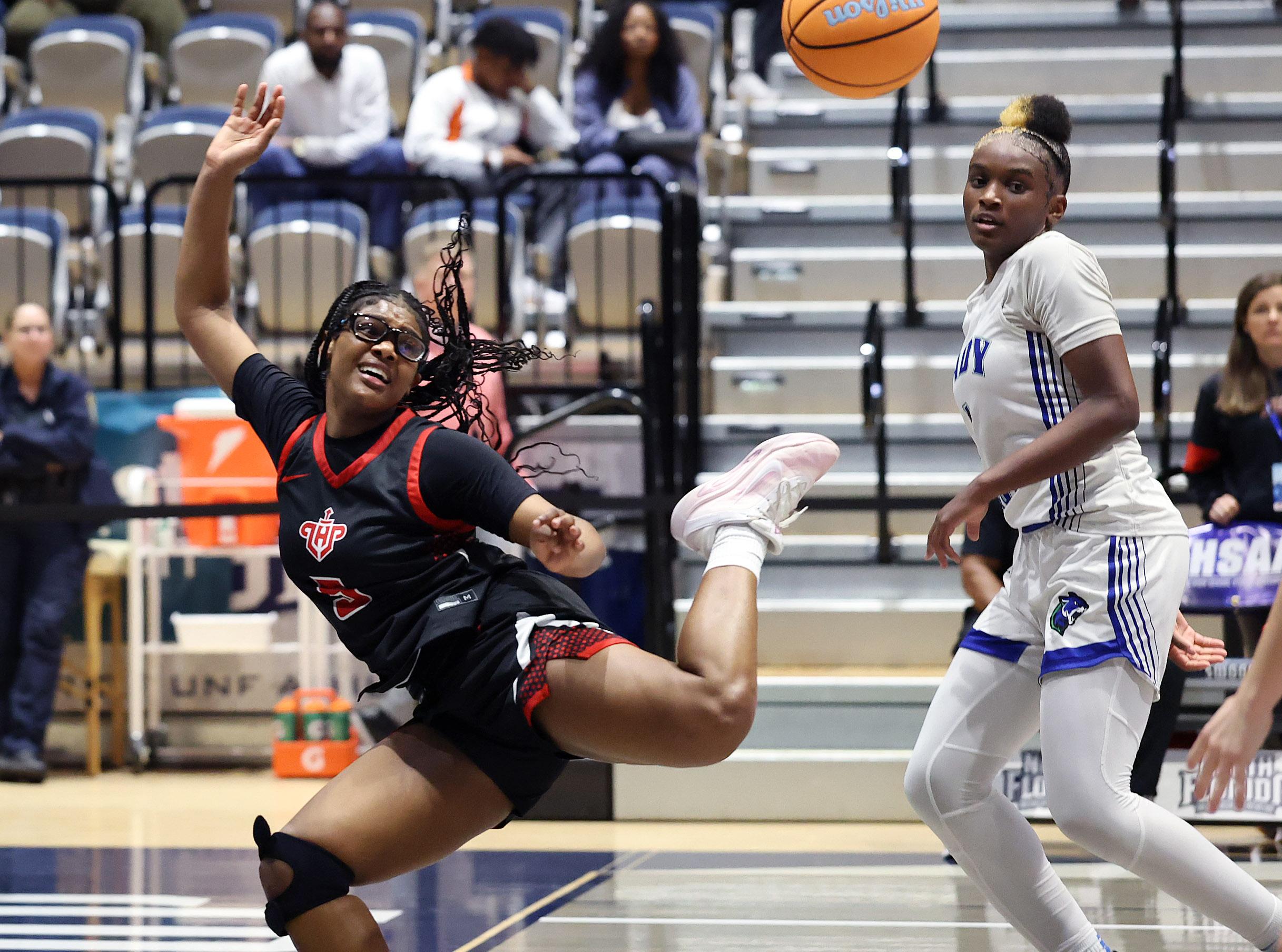Lake Highland player A'Niyah Liptrot (left) falls after getting fouled...