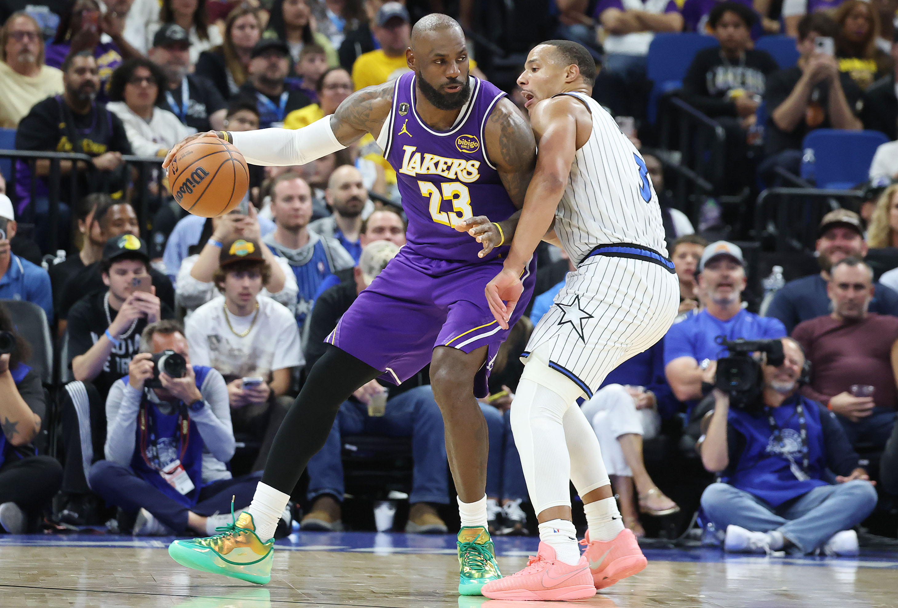 LA forward LeBron James (23) leans into Orlando guard Desmond...