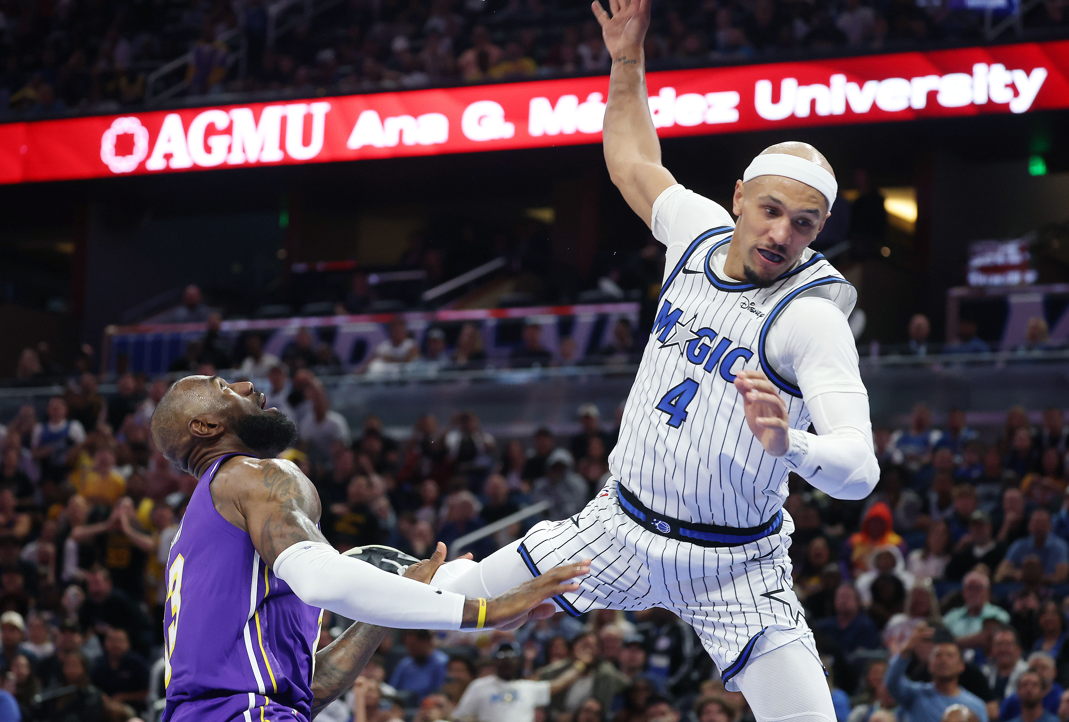 Orlando guard Jalen Suggs (4) falls beside LA forward LeBron...