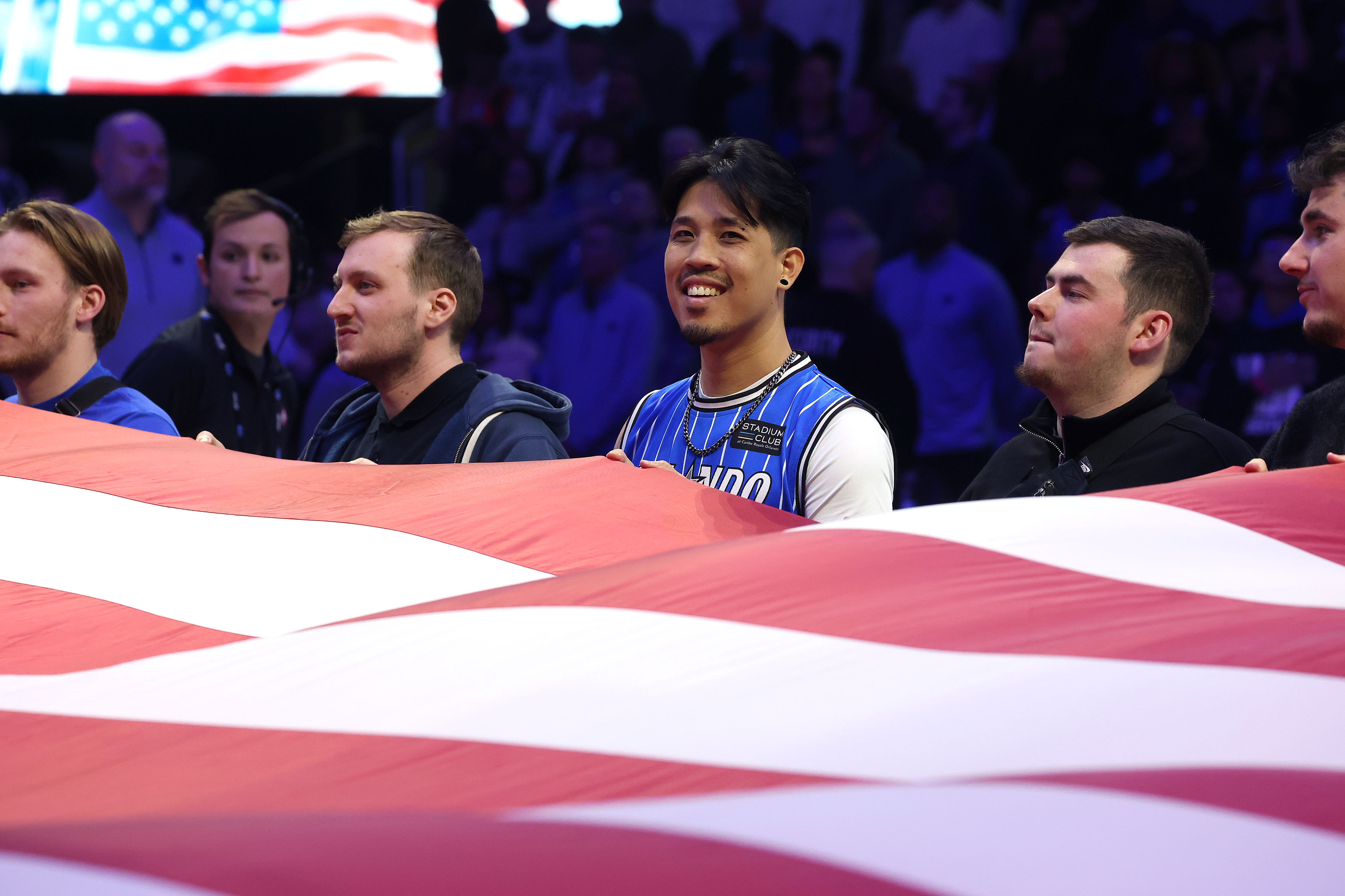 Fans hold the flag during the national anthem before the...