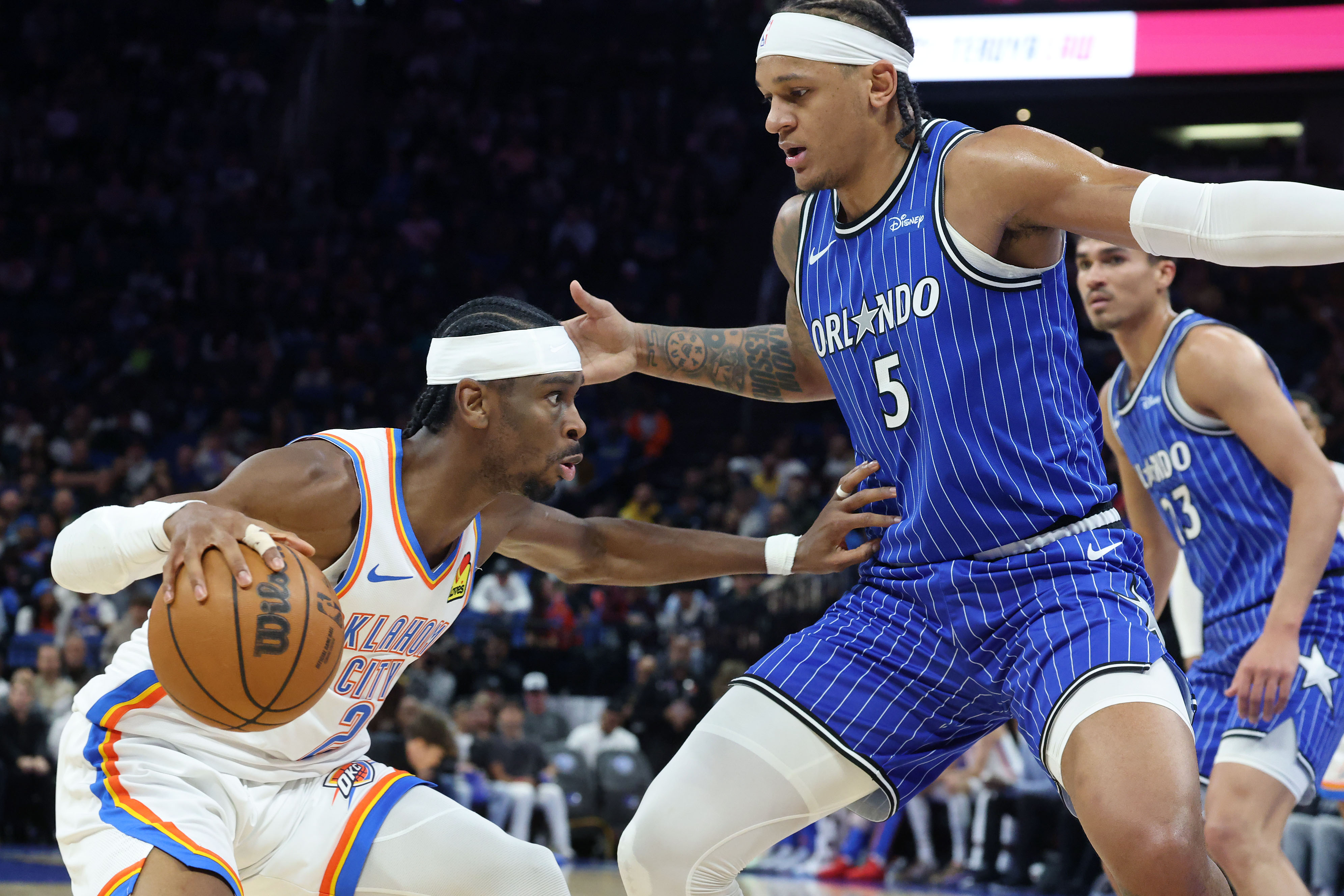 Thunder guard Shai Gilgeous-Alexander (left) shoves aside Magic forward Paolo...