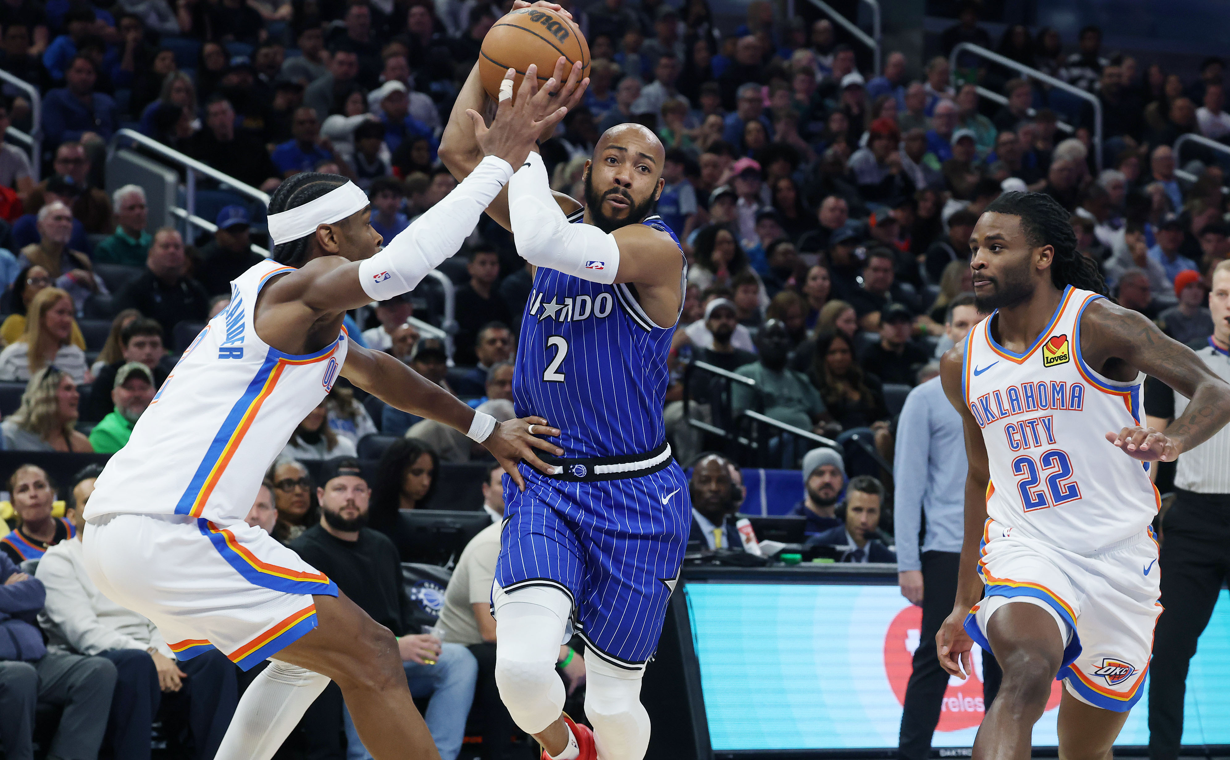 Magic guard Jevon Carter (middle) drives between Thunder guard Shai...