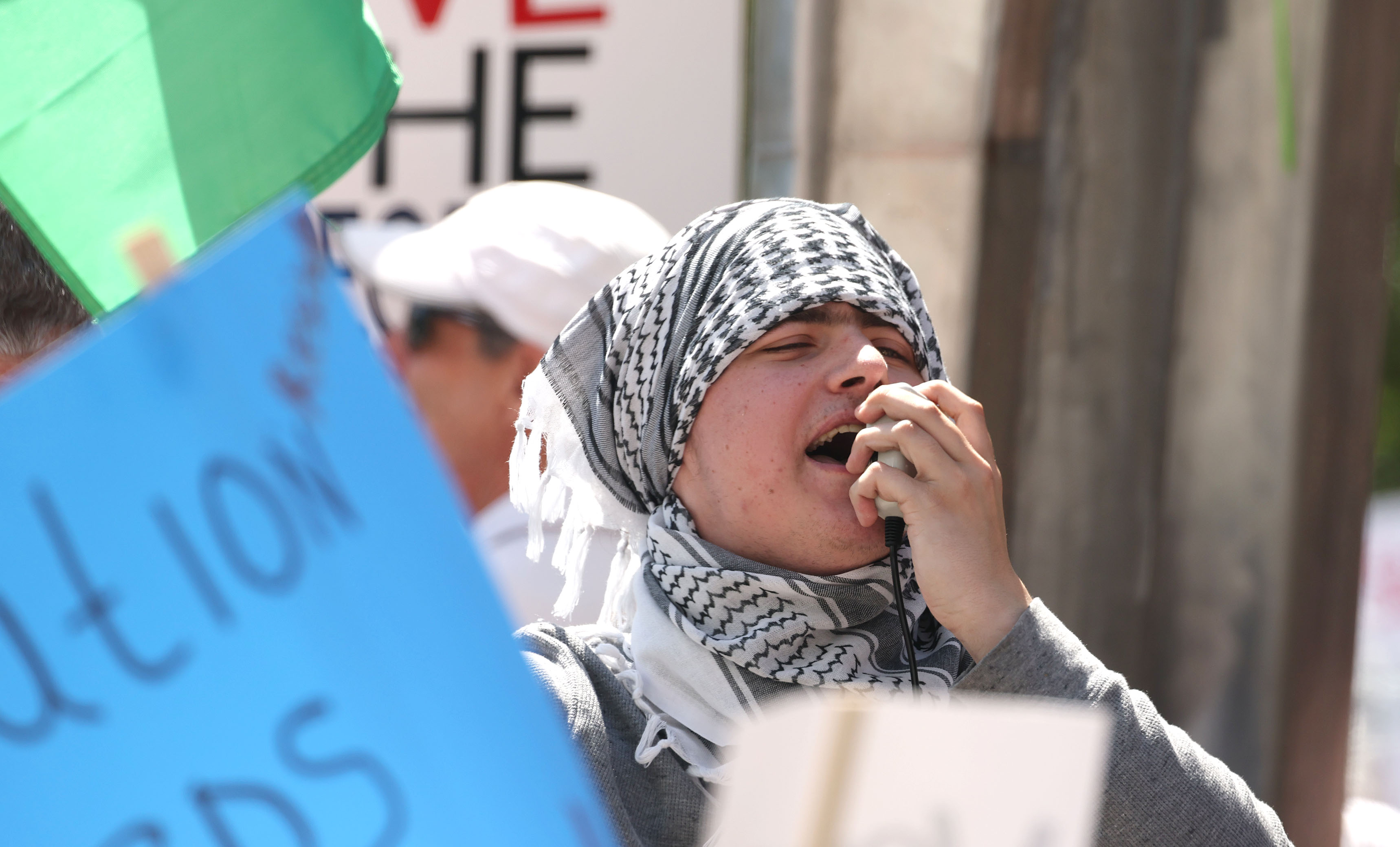 A protestor uses a megphone as he joins thousands in...
