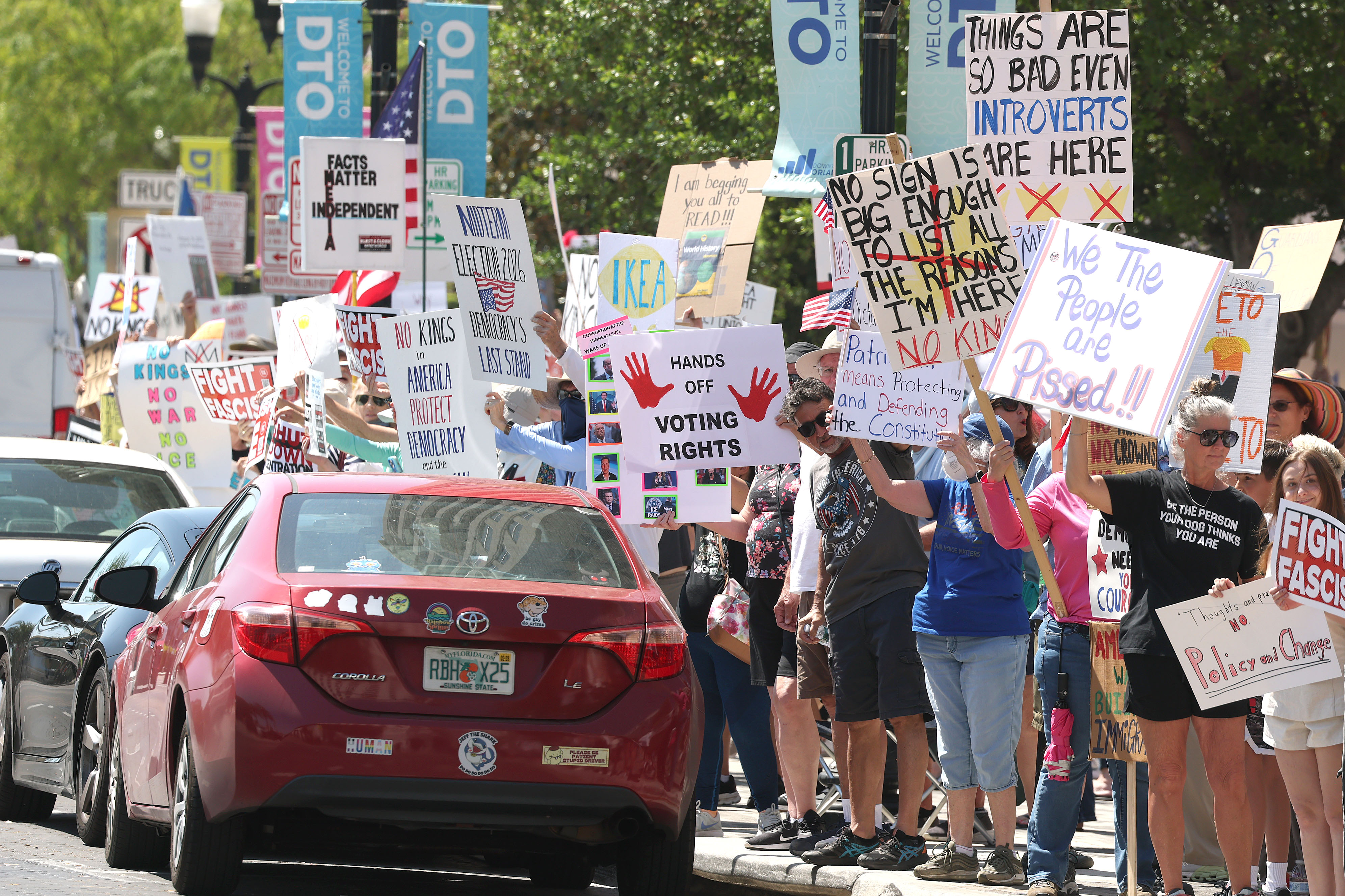 Protestors wave signs at passing traffic as they join thousands...