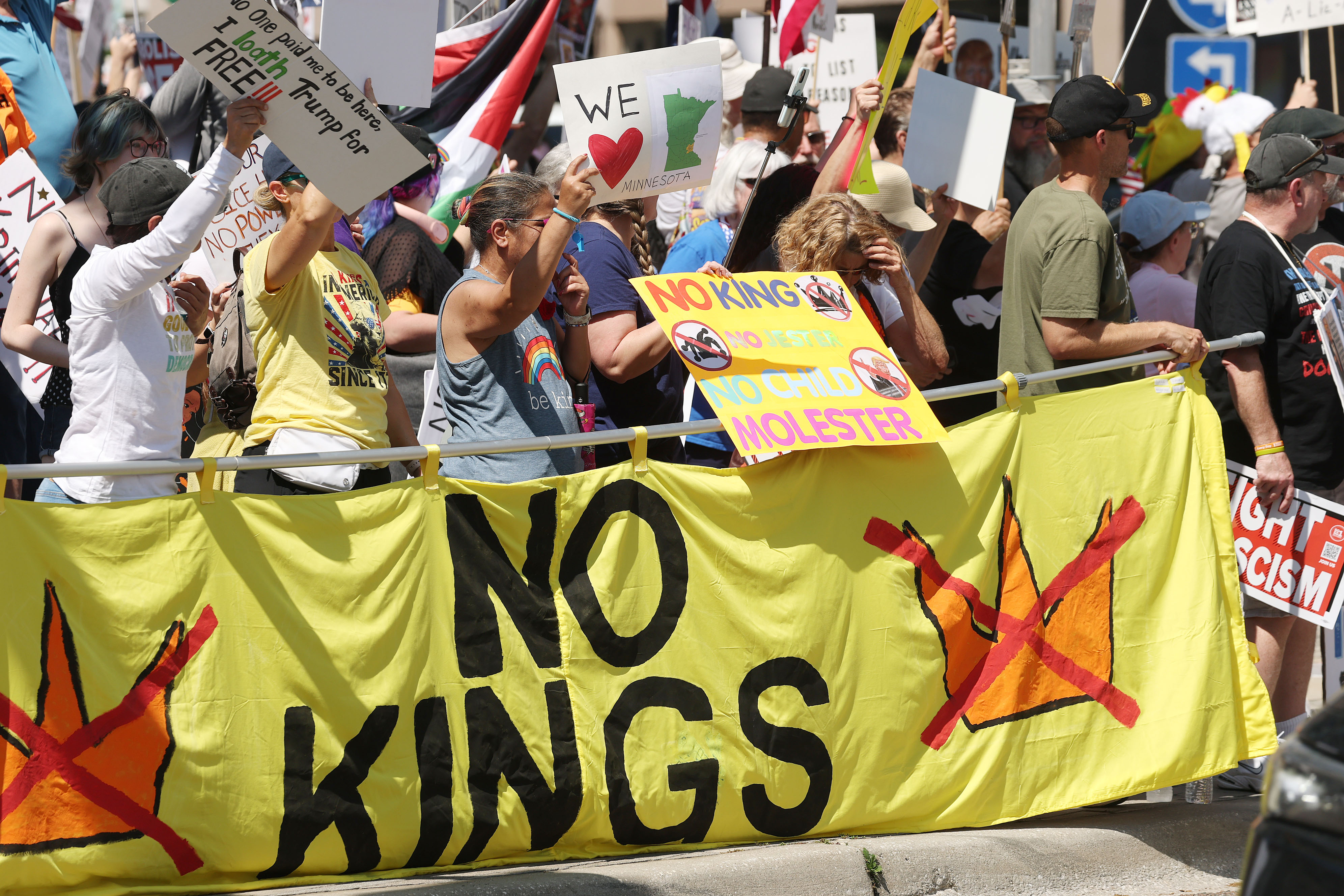 Protestors wave signs at passing traffic as they join thousands...