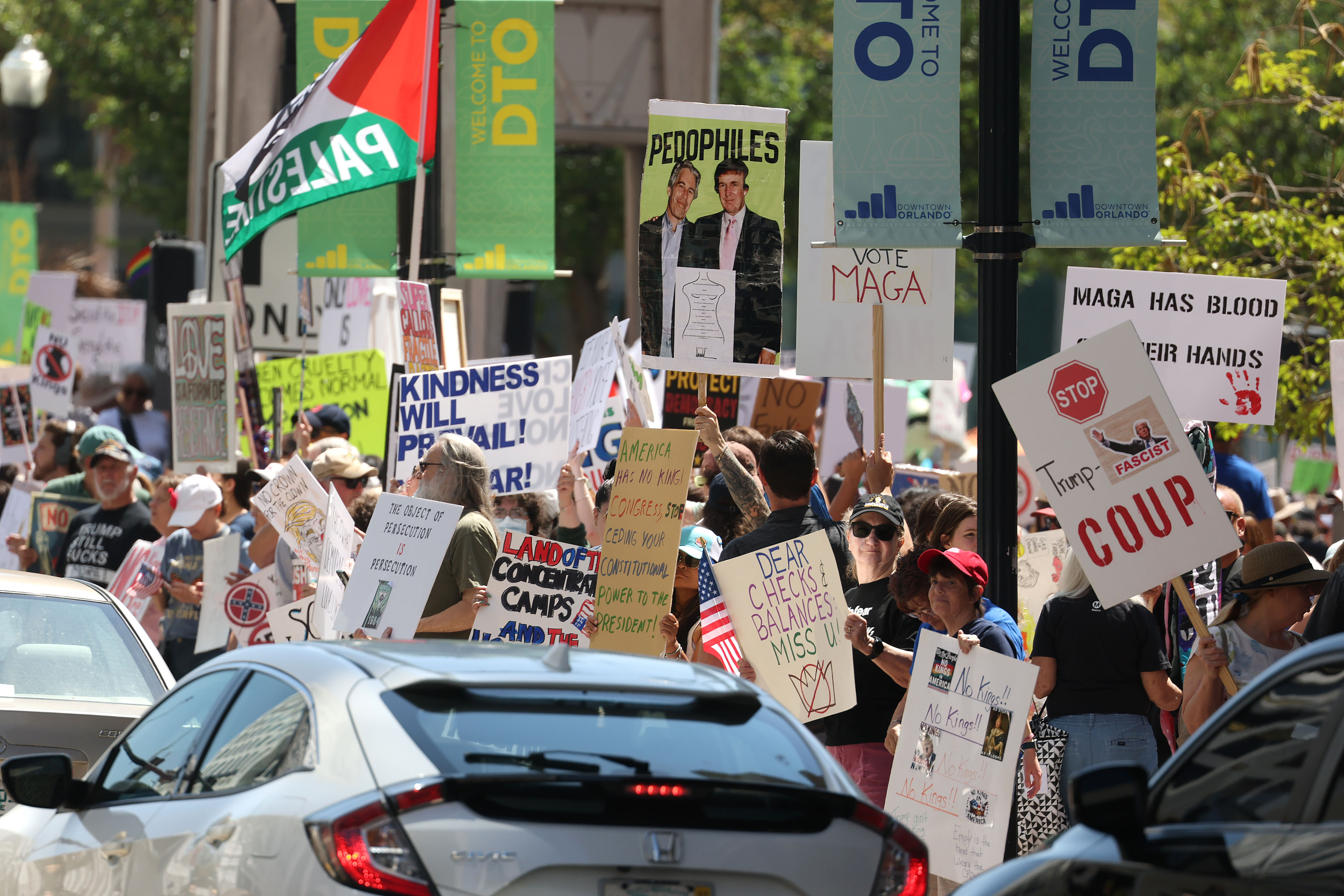 Protestors wave signs at passing traffic as they join thousands...