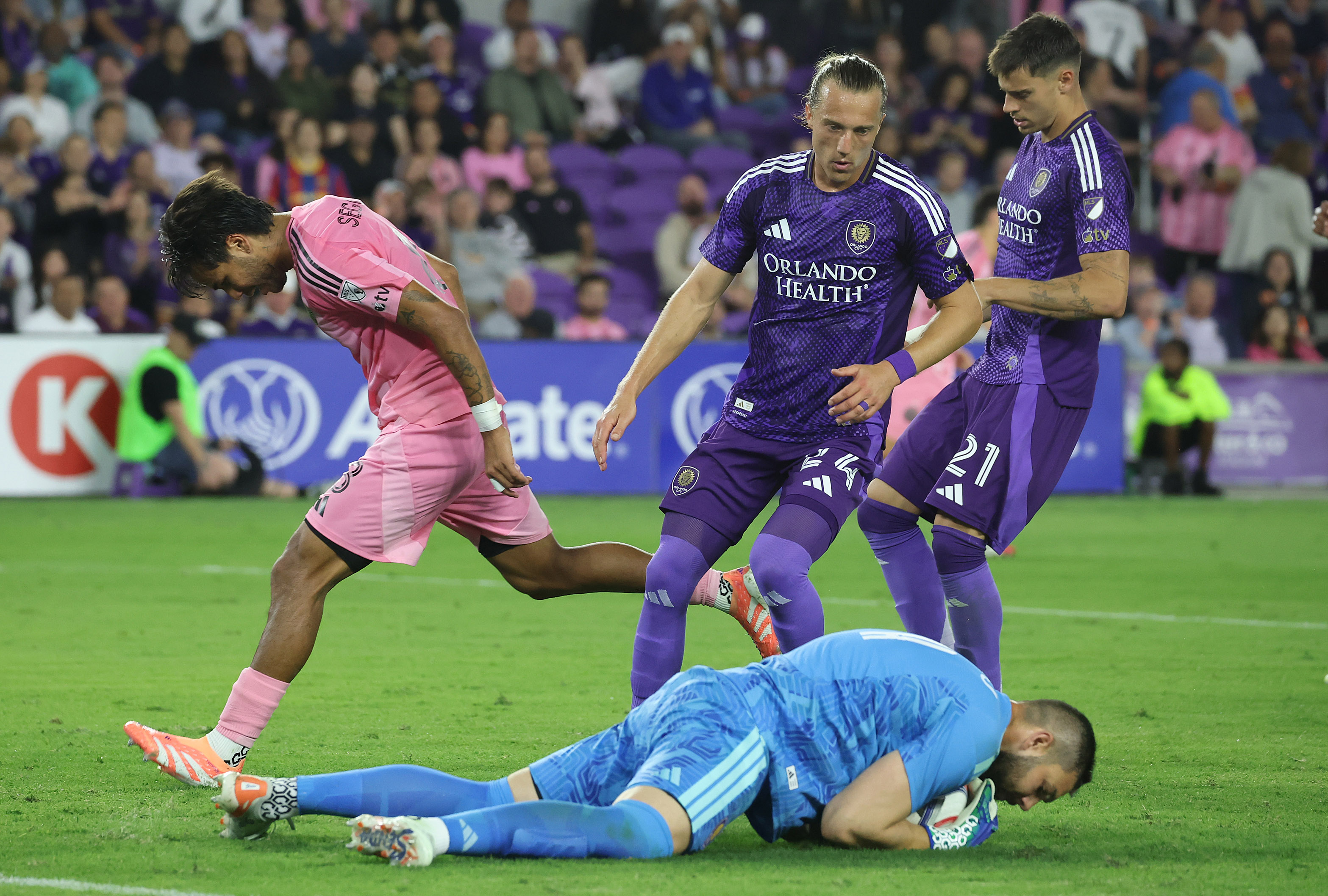 Orlando goalkeeper Maxime Crepeau (bottom) falls on the ball for...