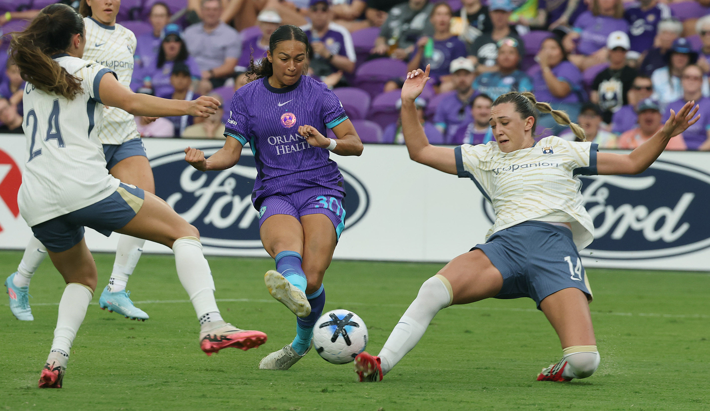 Orlando player Seven Castain (30) kicks between Seattle players Madison...