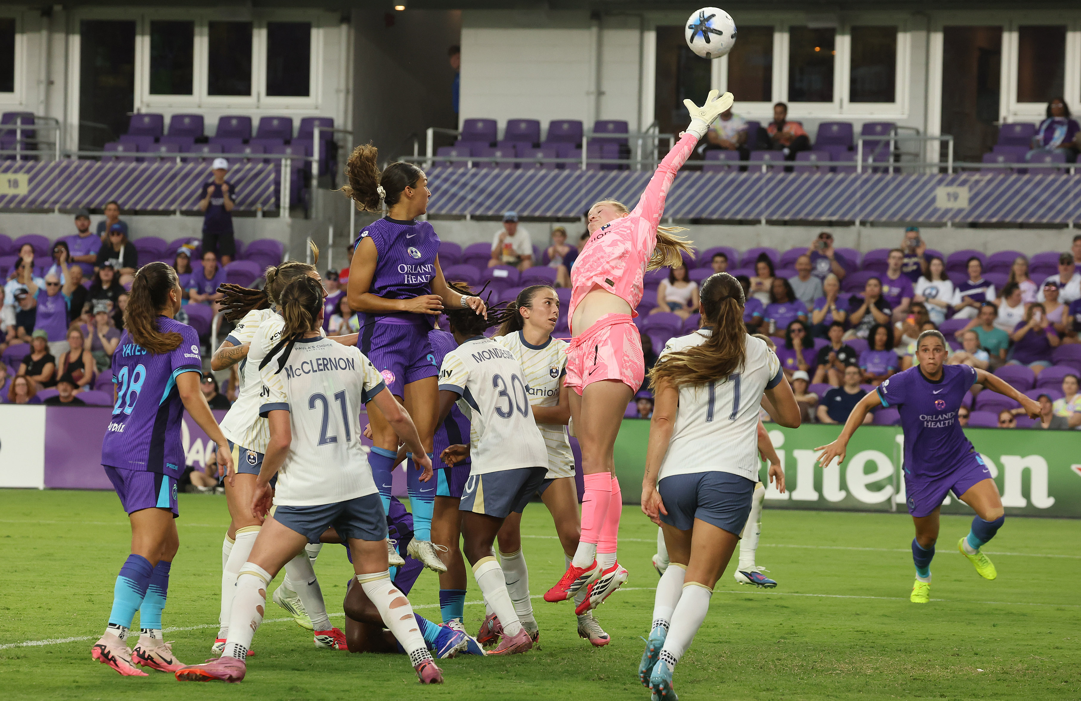 Seattle goalkeeper Claudia Dickey (middle) leaps to attempt to stop...