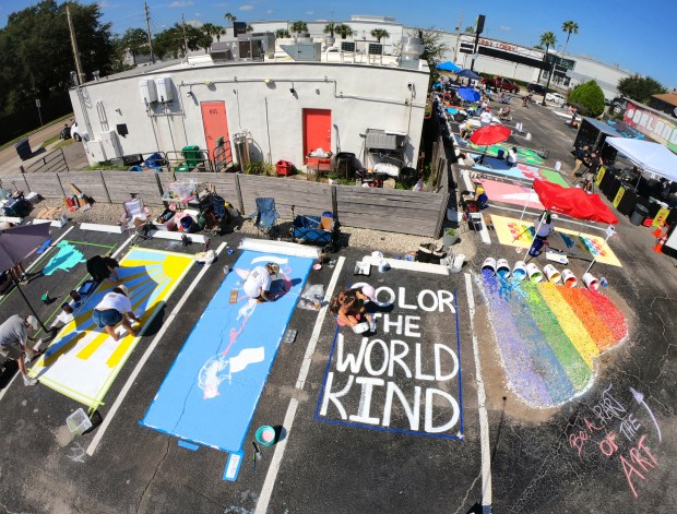 PAINTING WITH A PURPOSE Central Florida artists gather at the Se7enBites restaurant in Orlando for the "Parking Spaces for Pride" project, Monday, Sept. 15, 2025. The restaurant opened up 49 of its parking spaces to be custom painted in themes honoring those killed in the 2016 Pulse nightclub massacre and was organized in response to FDOT painting over a rainbow-colored crosswalk at the Pulse memorial on Aug. 21. (Joe Burbank/Orlando Sentinel)